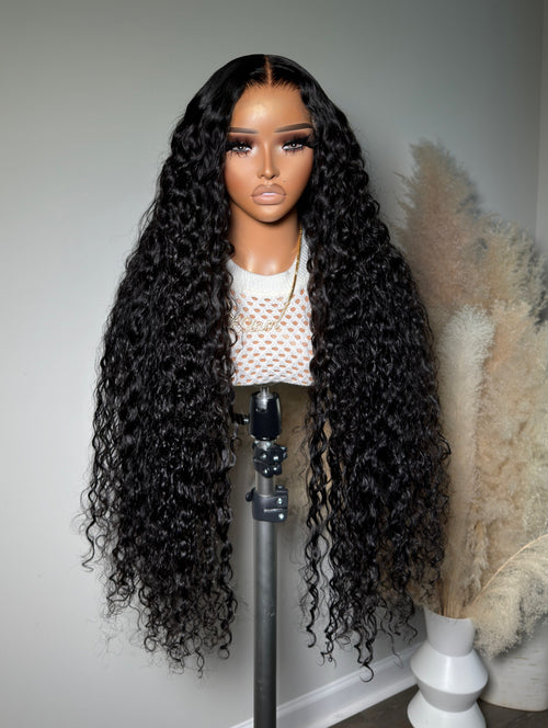Load image 1 in gallery view. A mannequin head displaying a wig with curly hair, wearing a white top with a heart pattern.