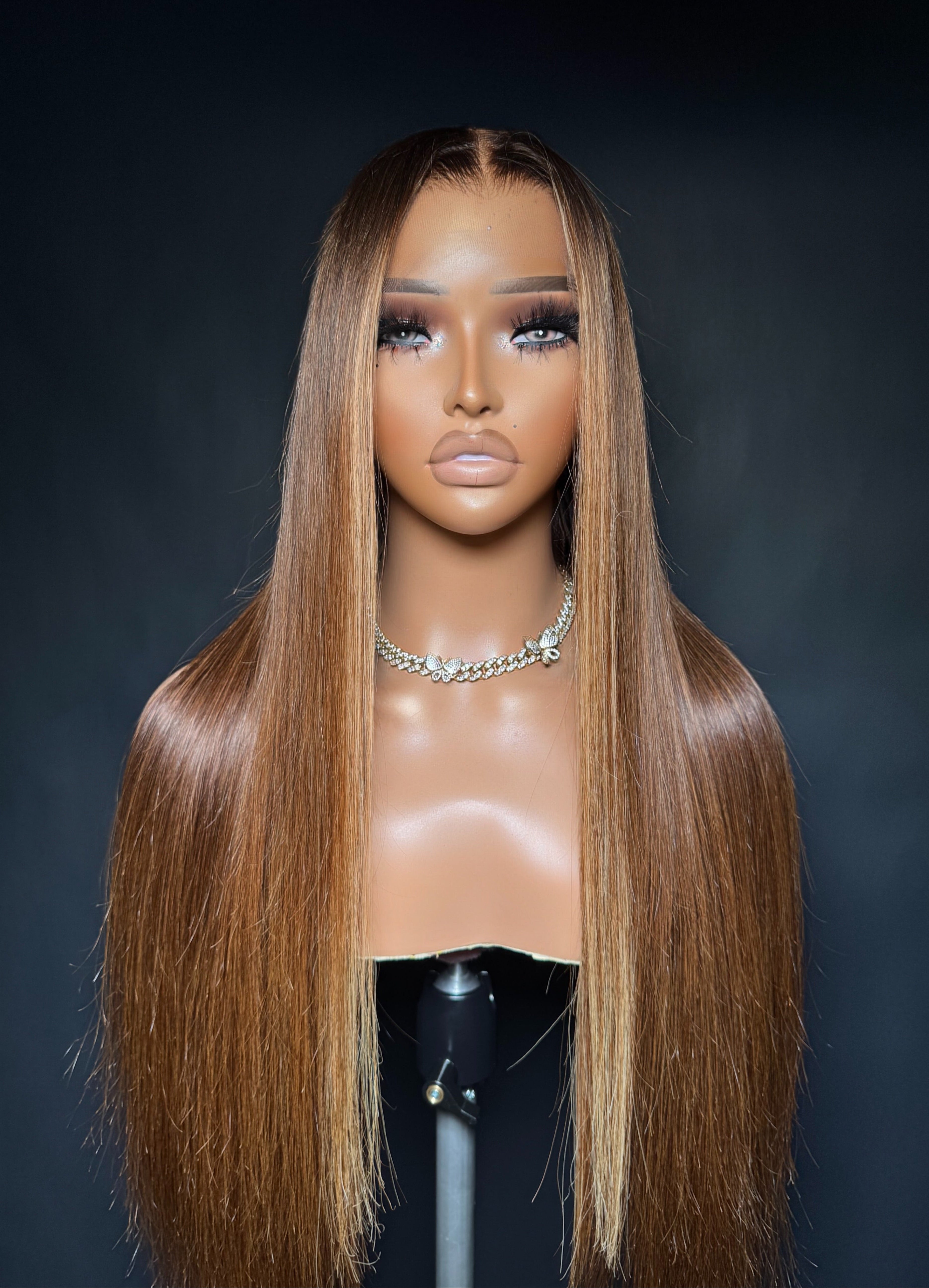 Mannequin head with a long brown wig on a dark background